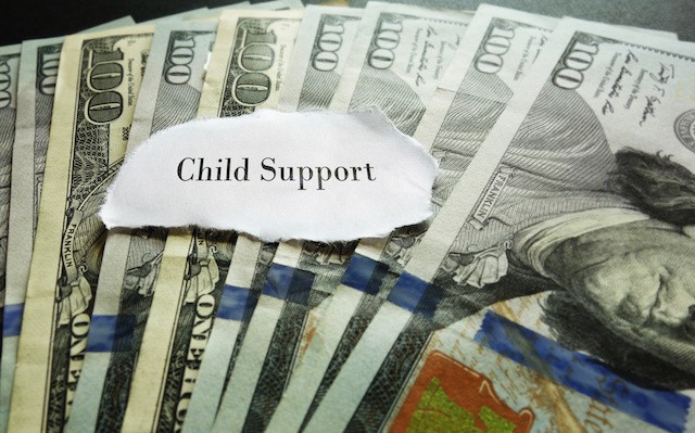 Closeup of hundred dollar bills with Child Support note