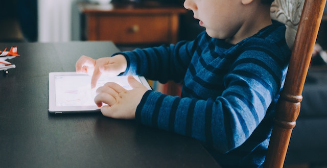 child sitting at table reading